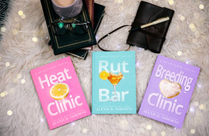 An aesthetic photo of Heat Clinic, Rut Bar, and Breeding Clinic on a white fur rug with string lights.