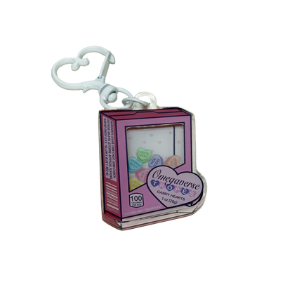 Acrylic shaker keychain shaped like a candy heart box that says omegaverse tropes. The candy hearts inside say let's nest, in rut 4 u, in heat 4 u, nice scent, bite me, and wanna rut?
