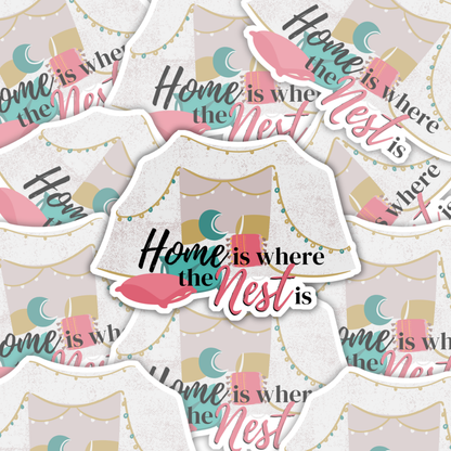 Vinyl sticker that shows a pillow fort that says home is where the nest is set on a backdrop of more stickers